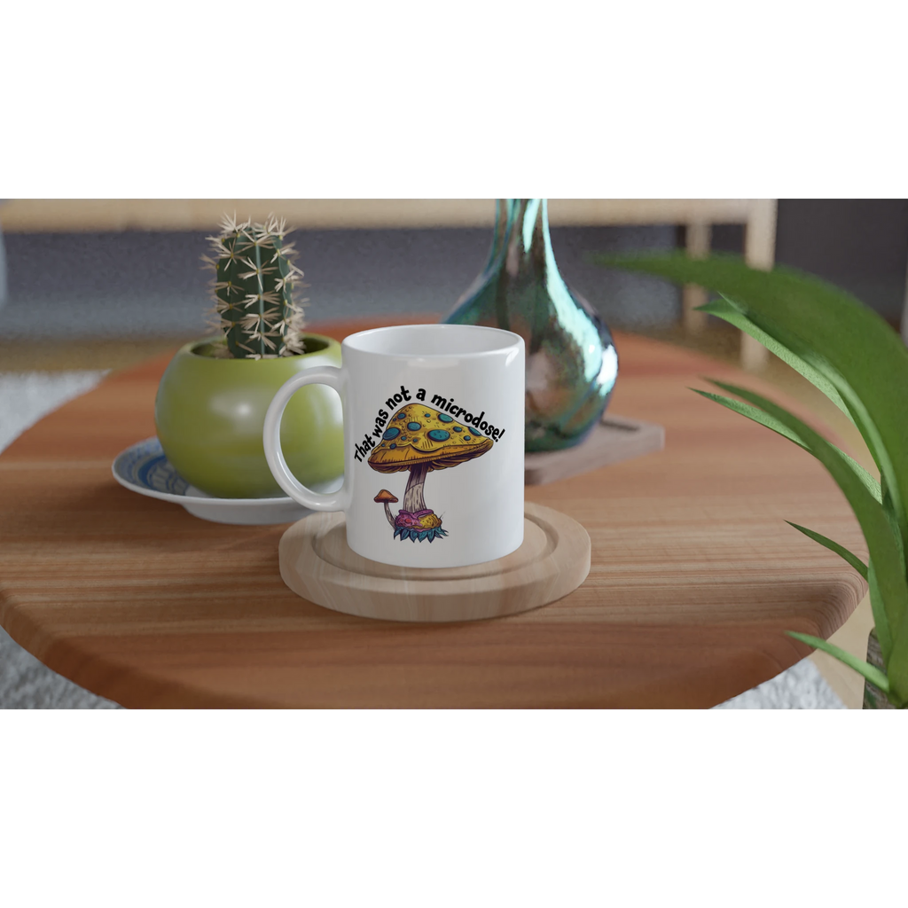 White ceramic mug with a funny Not a Microdose mushroom design on a table in a home setting
